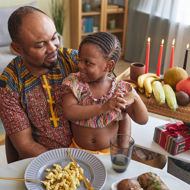 Dad and daughter celebrate Kwanzaa with food, candle lighting and gifts