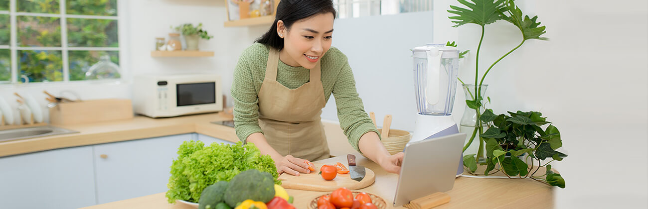 Asian Woman Cooks Using a Tablet
