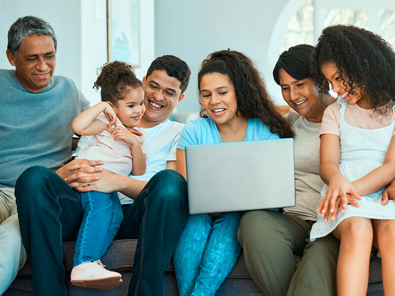 multi-generational family viewing a laptop together - Astound ensures your family a secure online experience
