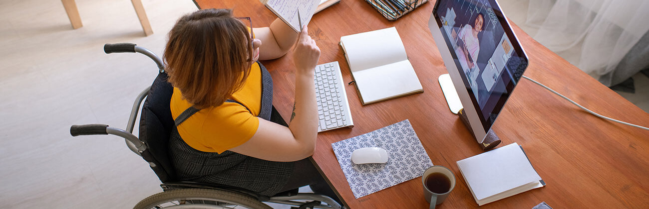 Young woman consulting online sits in a wheelchair