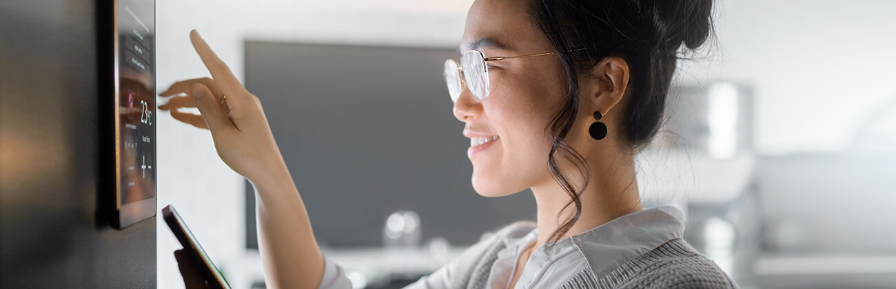 Woman changes settings on home automation system dashboard panel