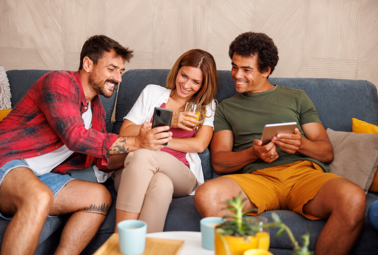 Friends on a couch looking at friend's phone