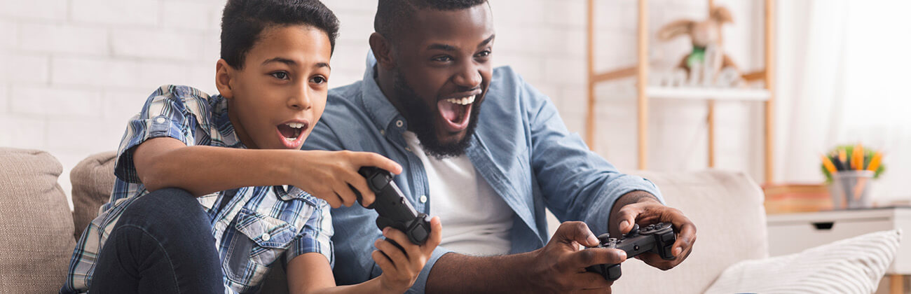 Father and son playing a video game on a couch