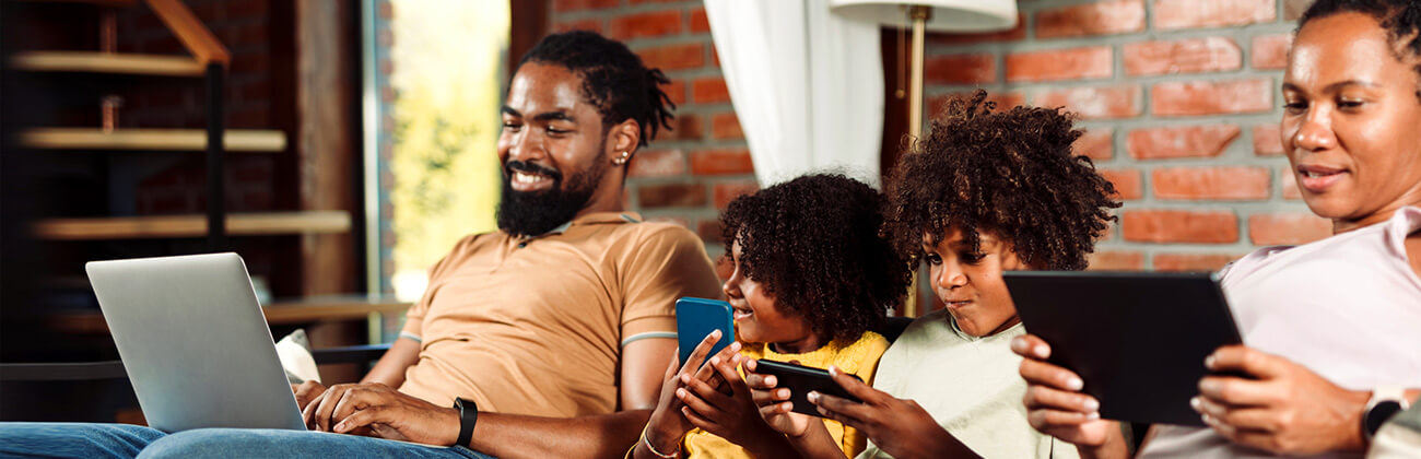 Family together on sofa each using their own devices