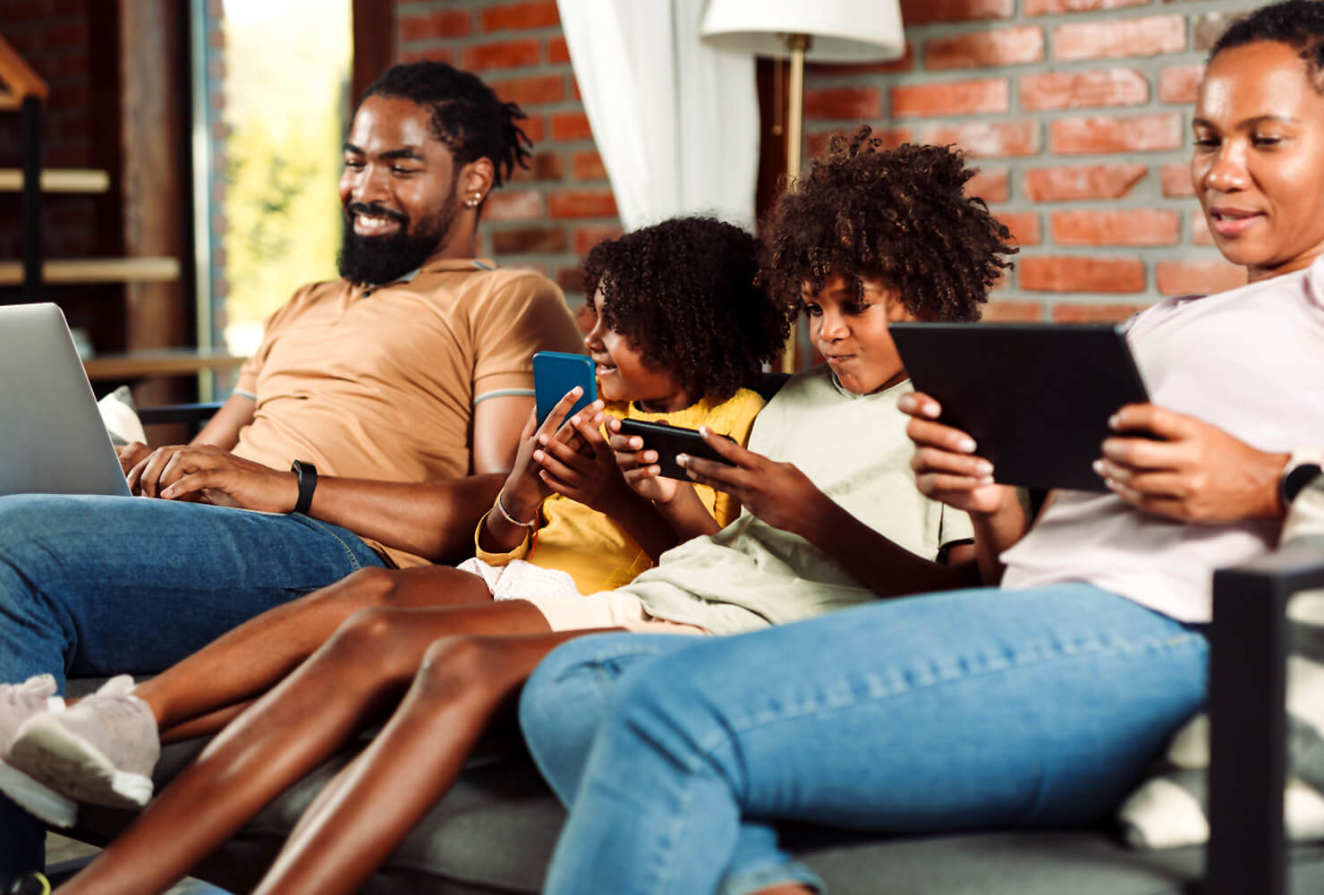 Family together on sofa each using their own devices