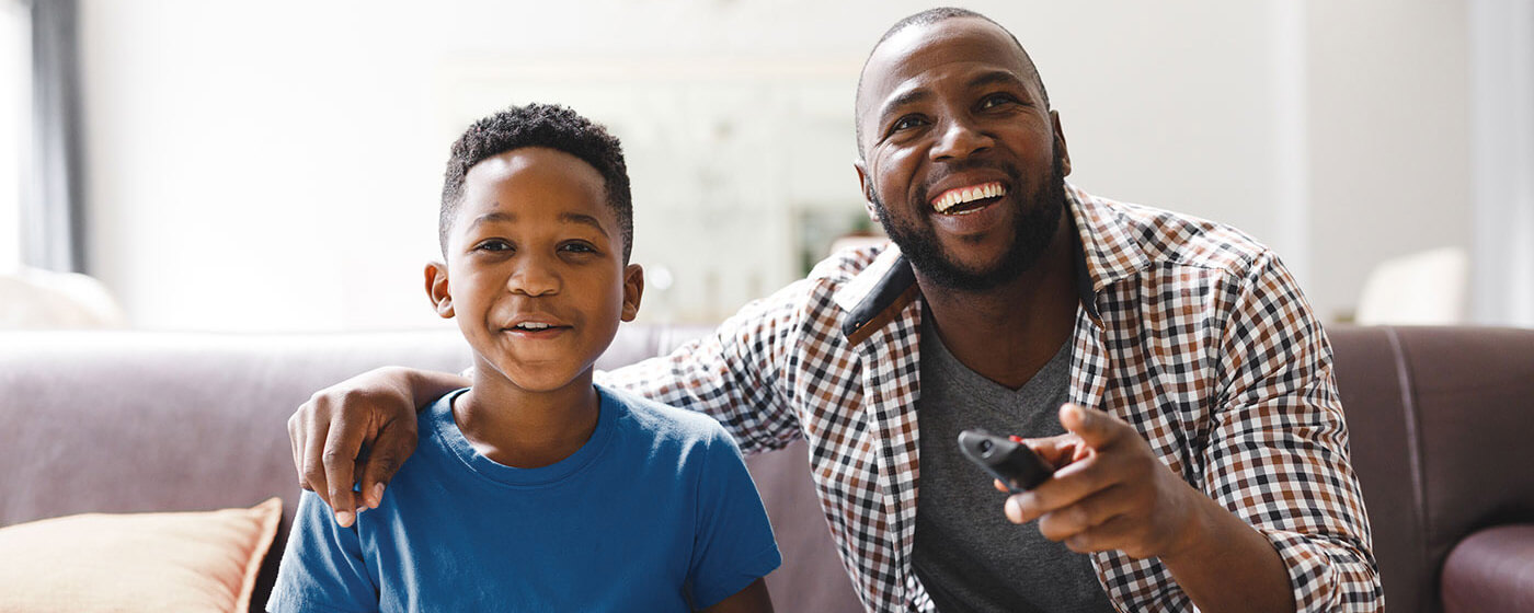 Dad and son watching favorite shows together on Father's Day