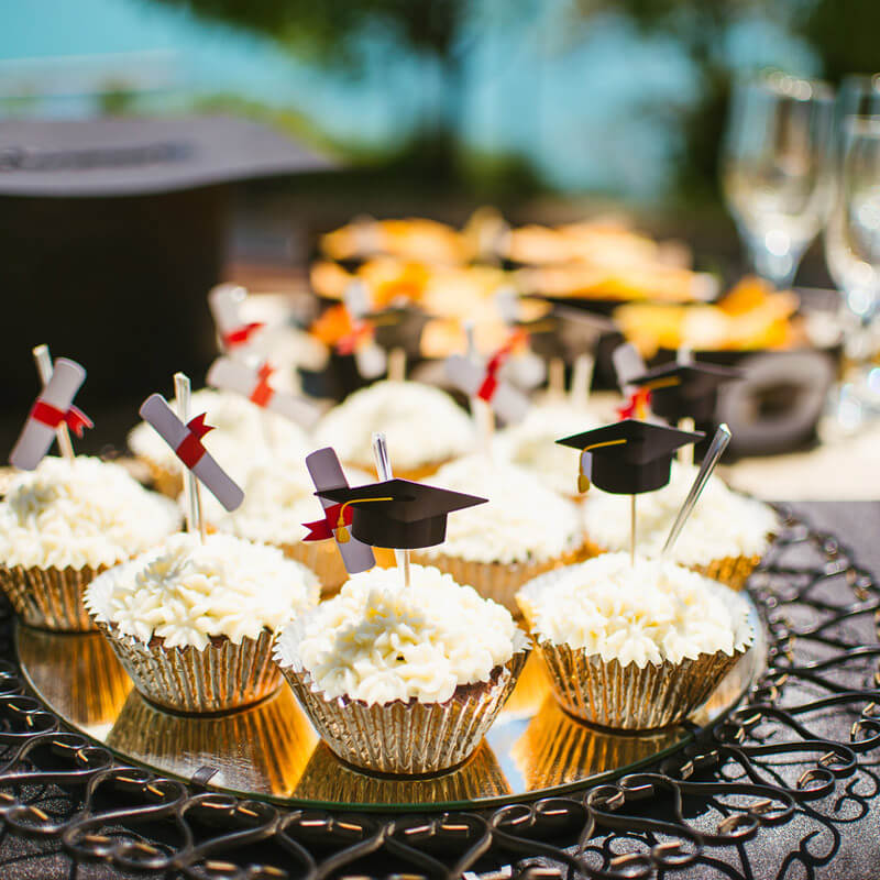 graduation themed cupcakes set out on a party table
