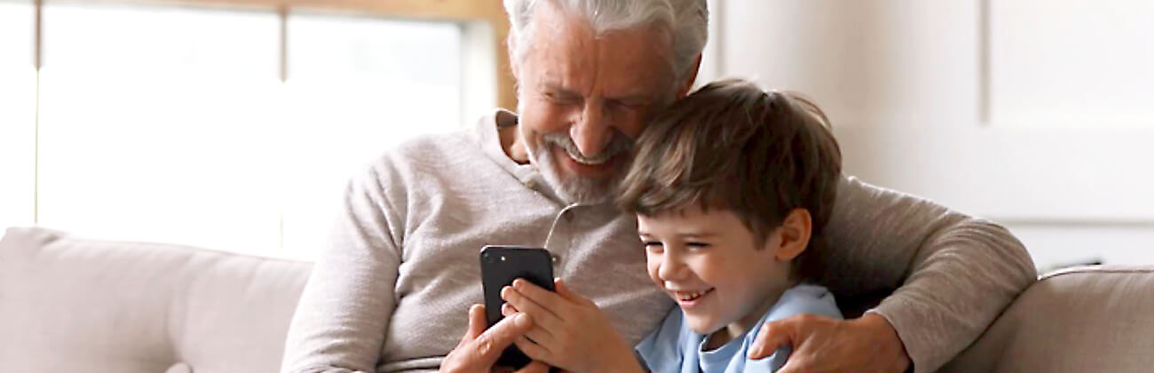 Best phone for kids - Boy and grandpa look at mobile phone together