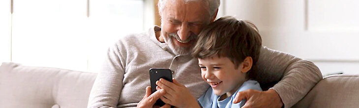 Best phone for kids - Boy and grandpa look at mobile phone together