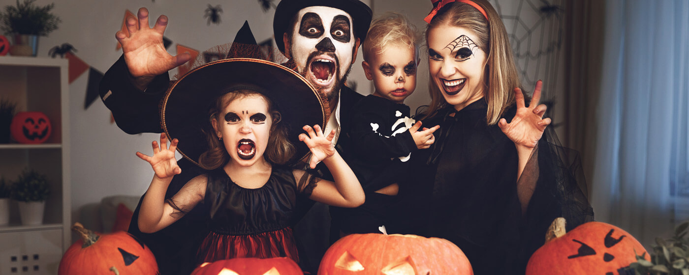 family in Halloween costume and scary decor