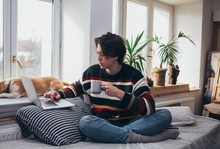 Young man with coffee checks out eero vs. Ubiquiti.