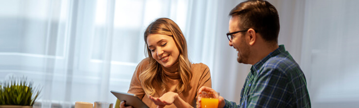 smiling couple checks out eero router specs at the breakfast table