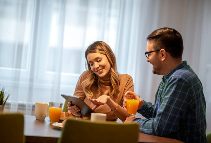 smiling couple checks out eero router specs at the breakfast table